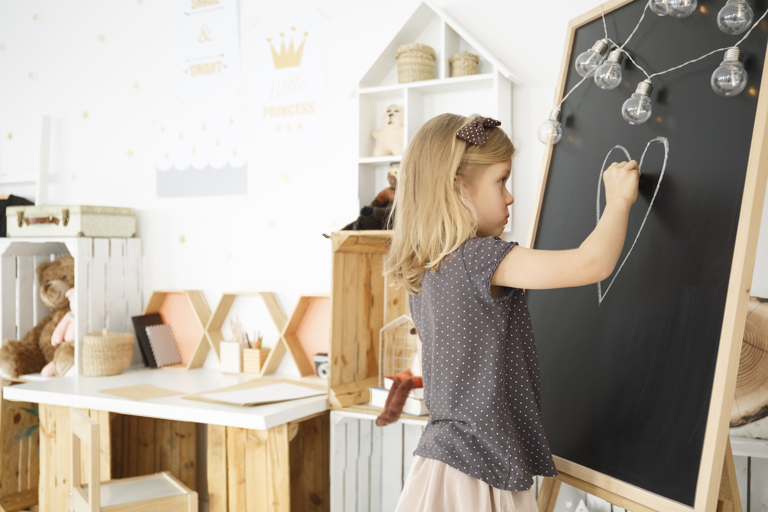 Small child drawing on a blackboard.